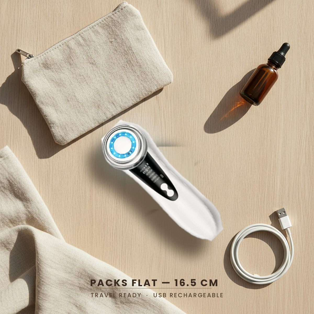 Facial massager packed flat with a linen travel pouch, serum bottle and USB cable