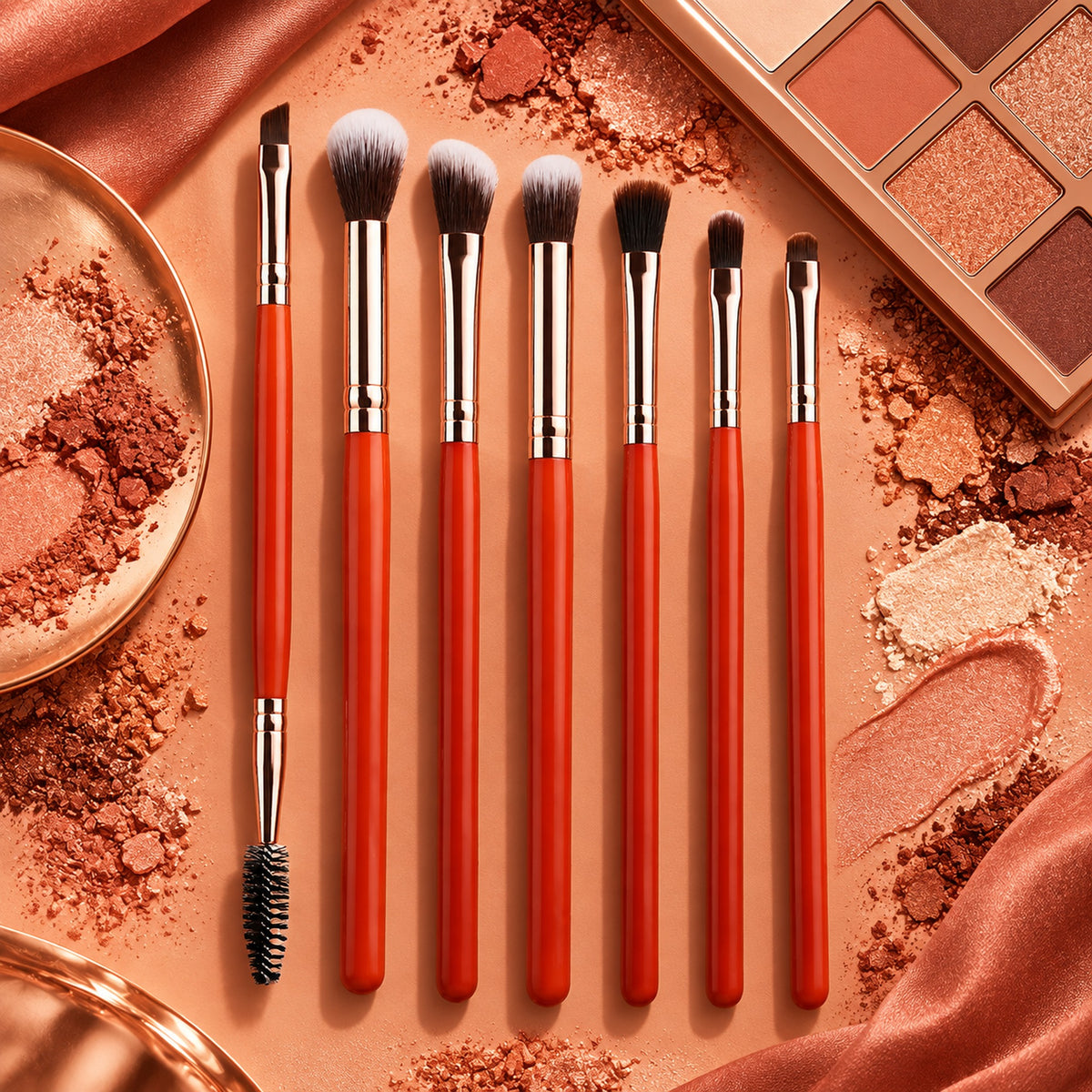 Seven orange-red eye brushes laid out with terracotta eyeshadow pigments