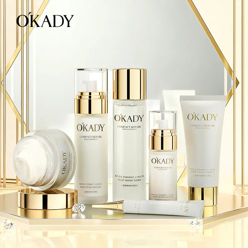 All six Okady Bifid Yeast skincare products styled together: cleanser, toner, essence, emulsion, eye cream and face cream.