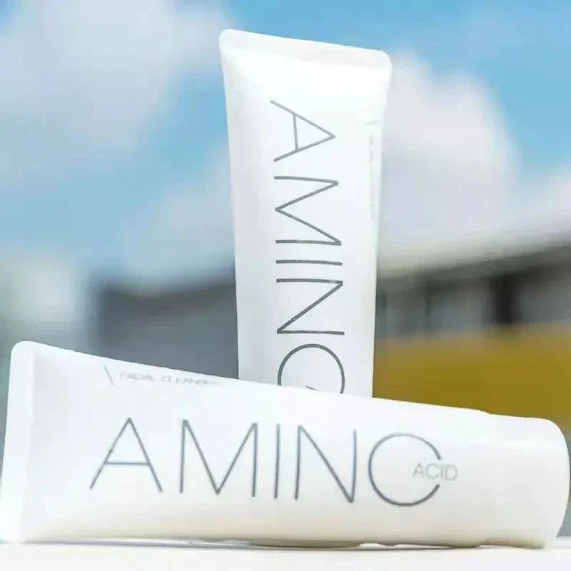 Two white tubes labeled 'AMINOC' with a blurred outdoor background.