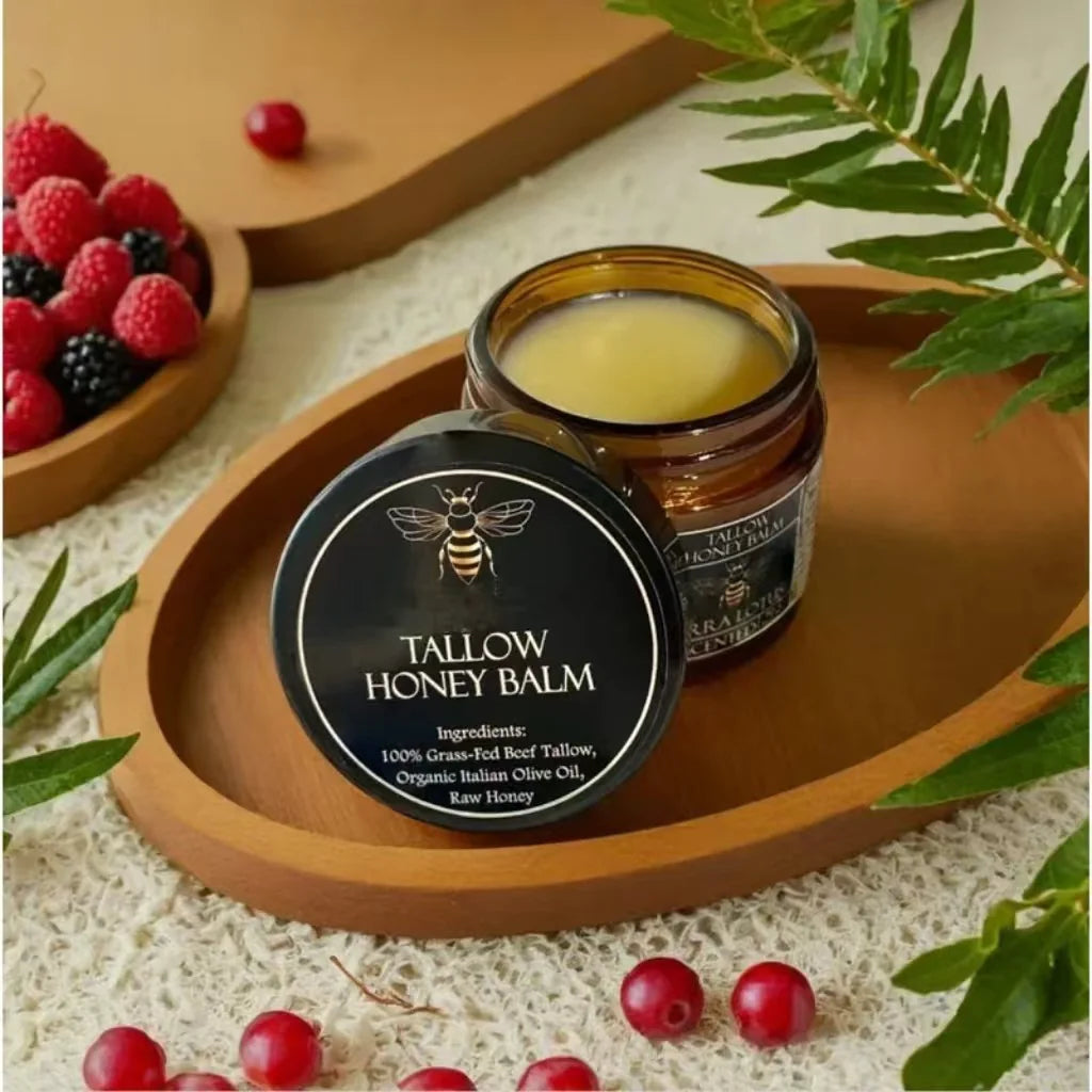 Tallow Honey Balm jar and tin on a wooden tray with berries and leaves.
