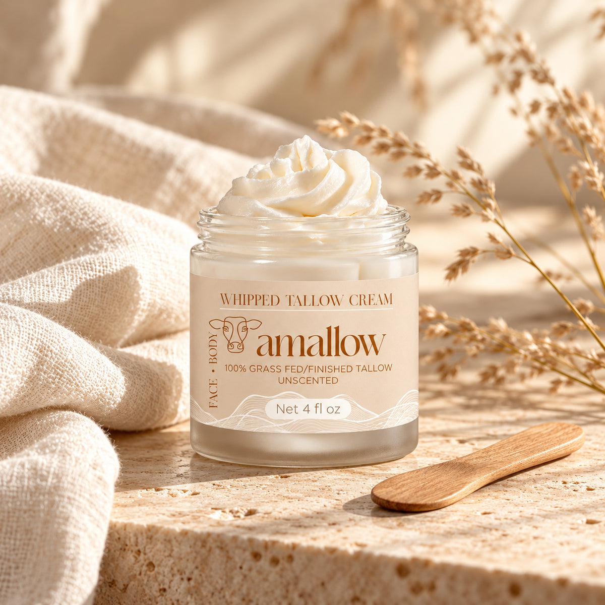 amallow whipped tallow cream on stone with linen, dried grasses and a wooden spatula