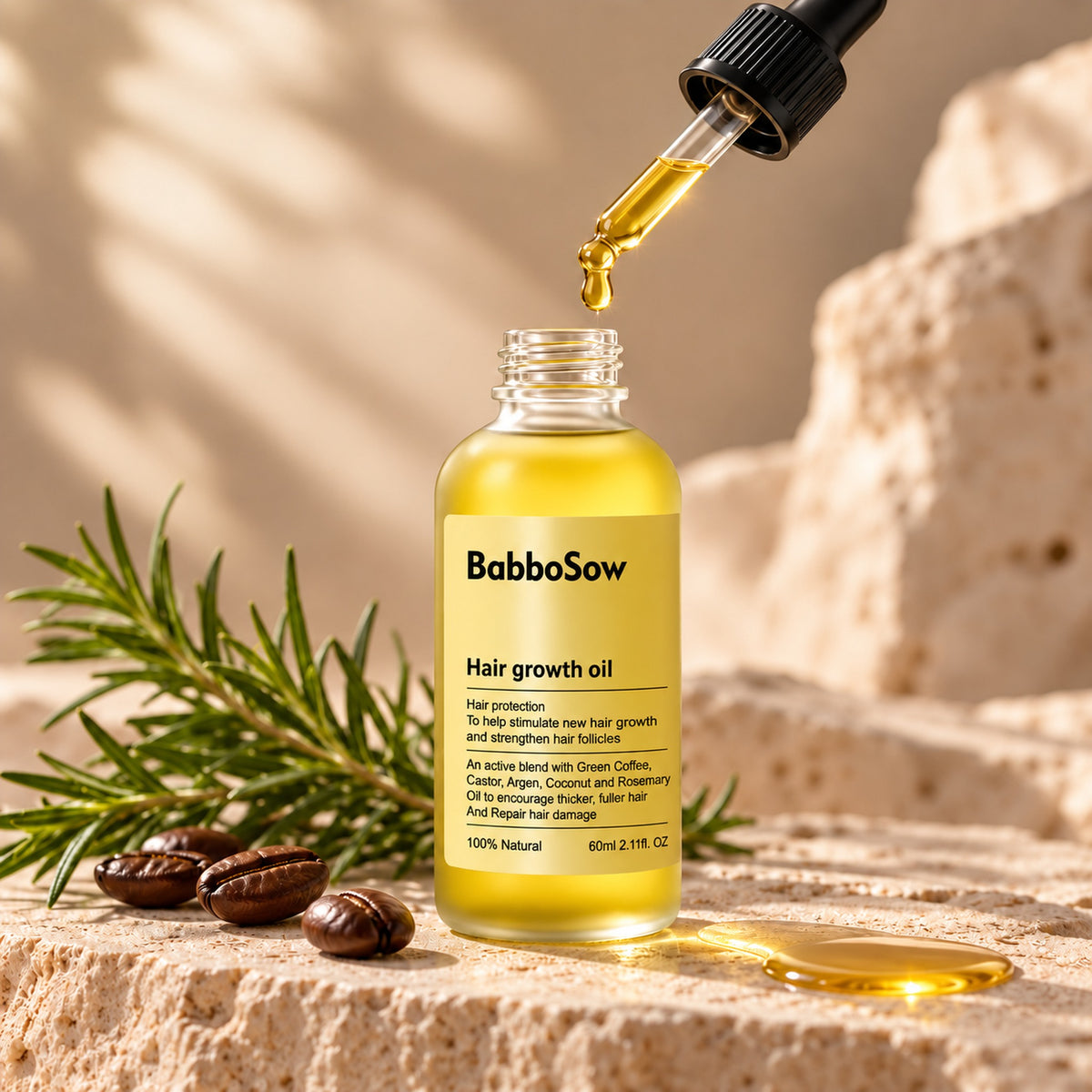 Golden hair oil dripping from the dropper into the BabboSow bottle
