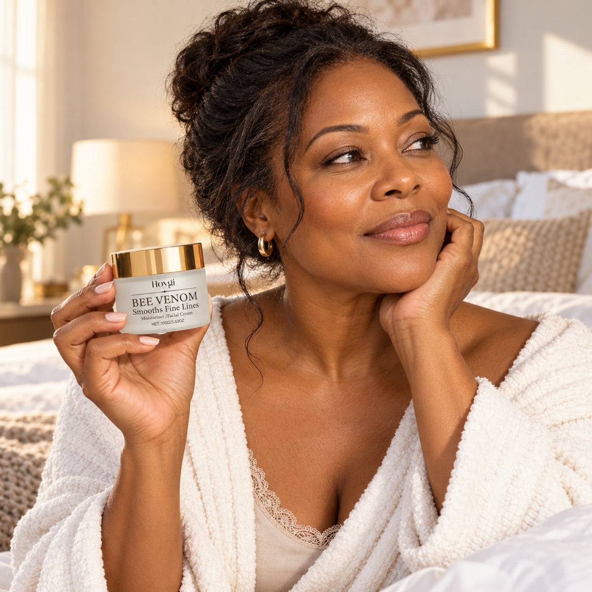 Woman holding the 100 g Hoygi Bee Venom jar in a bright bedroom