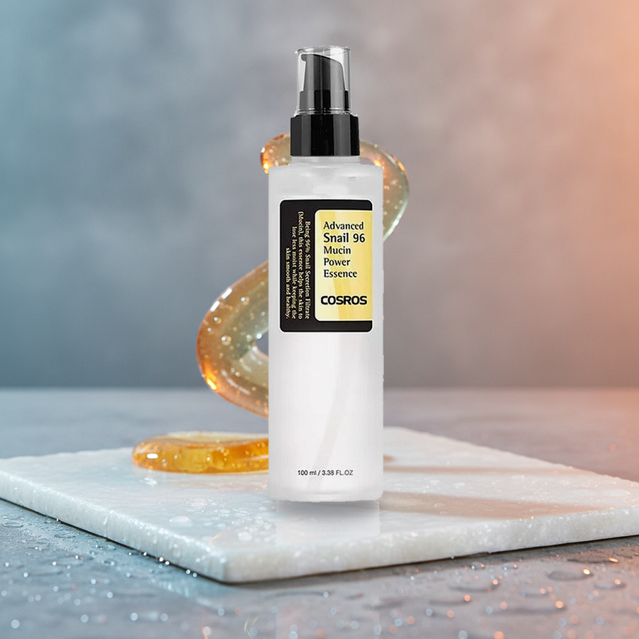 Snail 96 Mucin Power Essence — styled on wet pearl marble with a glistening mucin ribbon