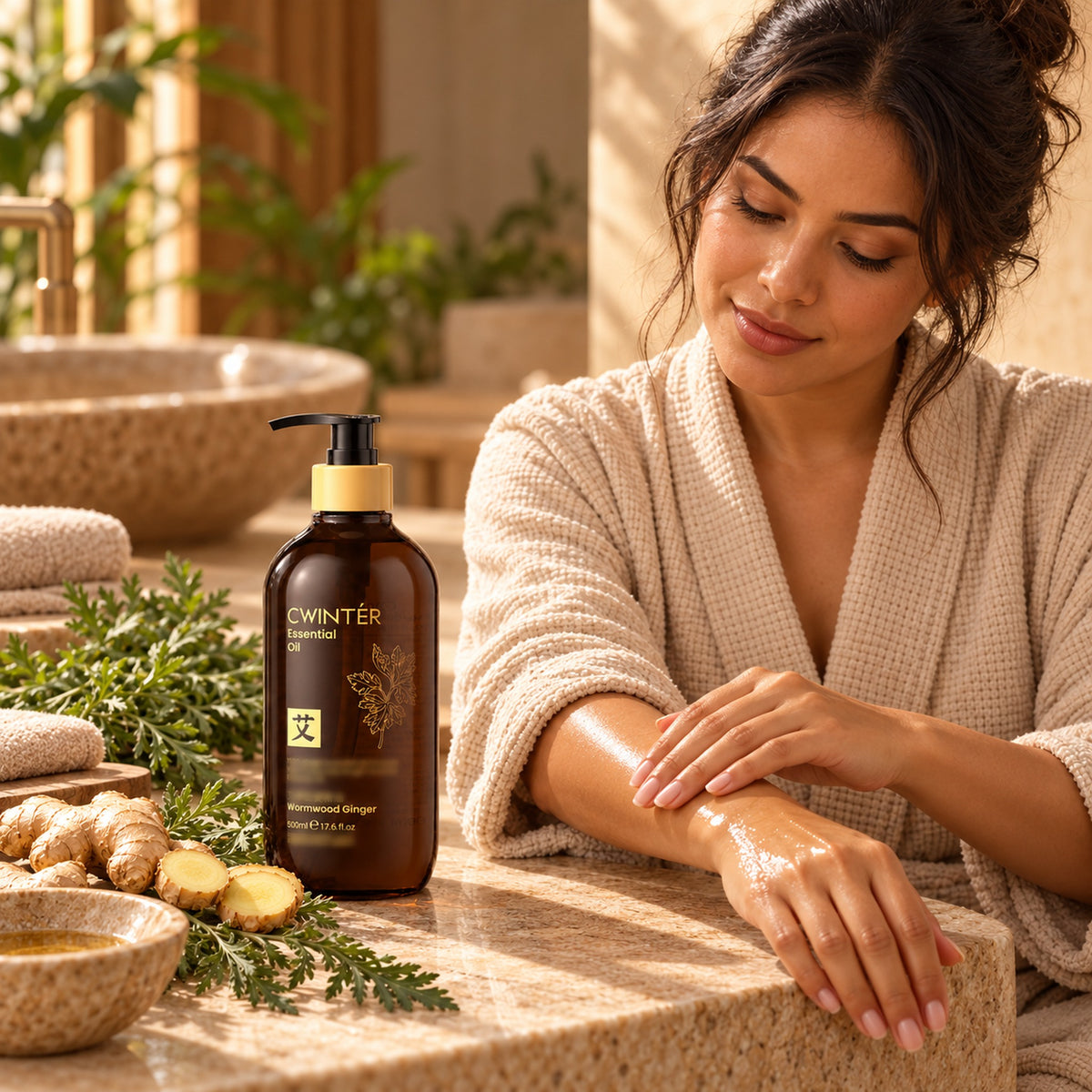 Woman in a robe massaging Wormwood Ginger body oil into her forearm at a spa counter