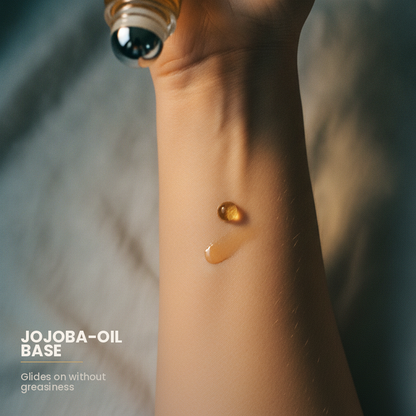 Macro of an amber jojoba oil bead and its trail on an inner wrist with the roller ball above, captioned jojoba-oil base, glides on without greasiness