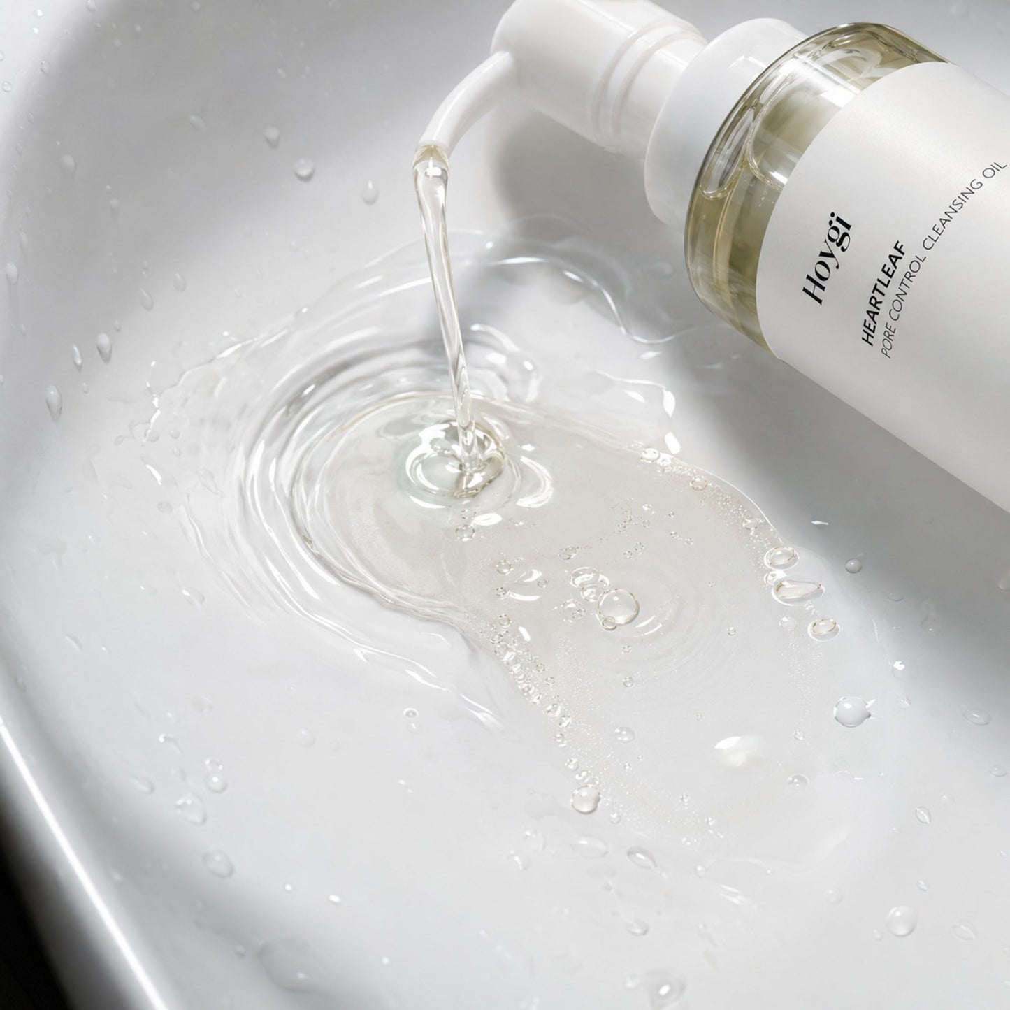 Hoygi pump dispensing clear cleansing oil into water for a macro emulsification view