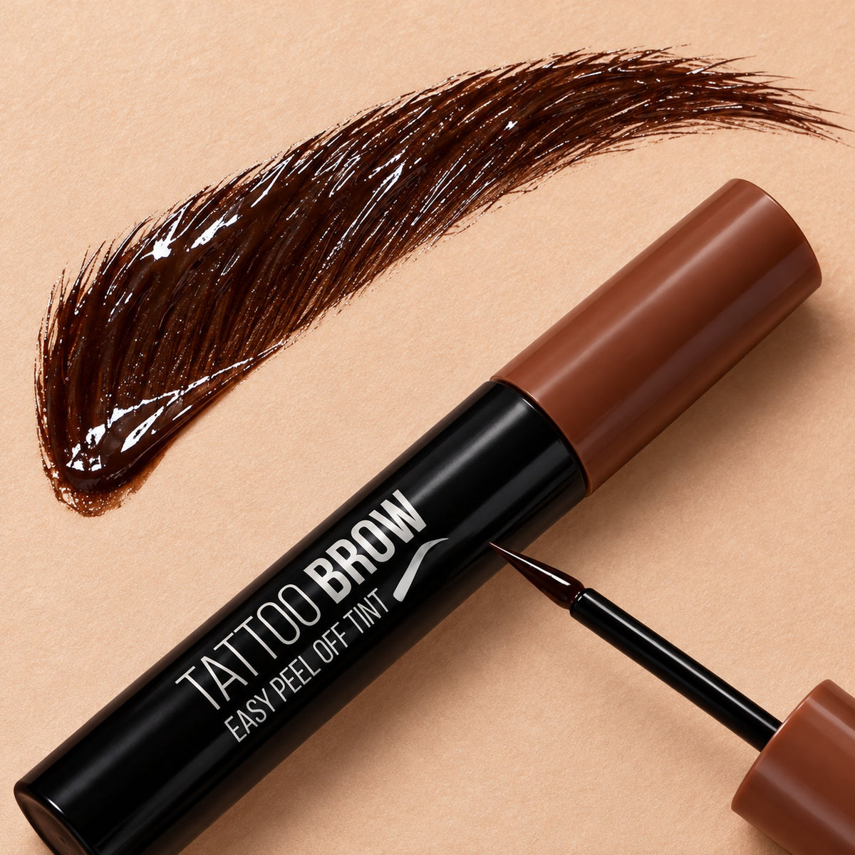 Glossy dark brown peel-off brow gel stroke next to the brush tip