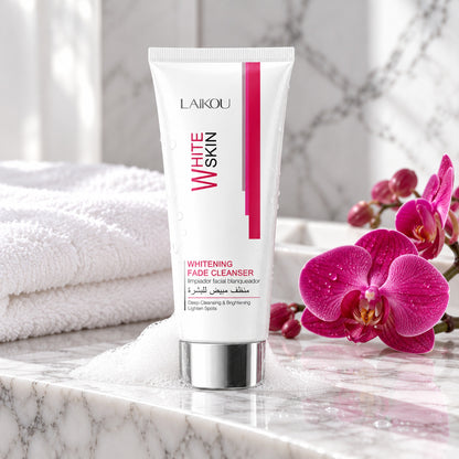 LAIKOU White Skin cleanser on a marble bath ledge with foam, towel and magenta orchid for a cleansing spa moment
