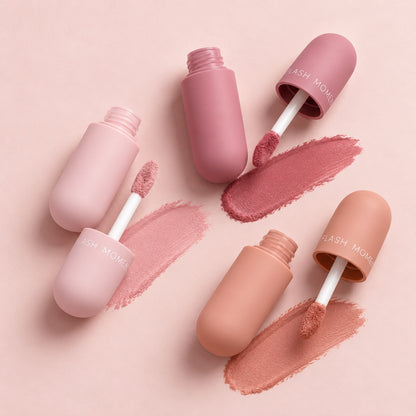 Three open capsule lip glosses with doe-foot wands and velvety matte swatches