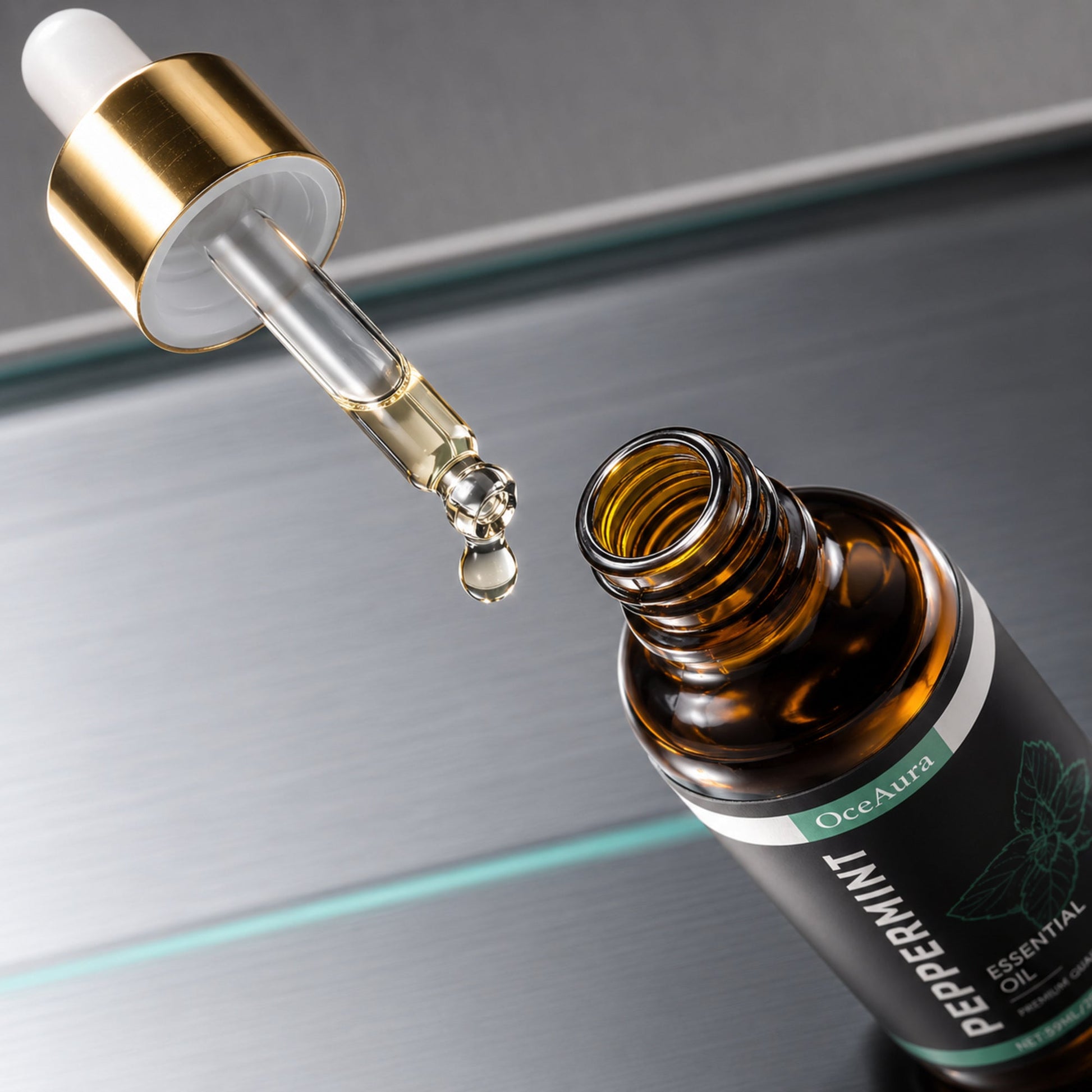 OceAura peppermint oil glass dropper and golden droplet shown in crisp macro detail