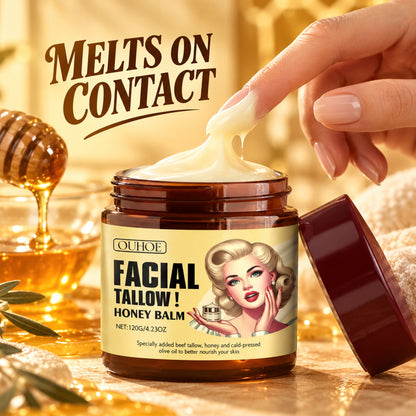Buttery tallow honey balm melting on contact as a fingertip scoops from the open amber jar