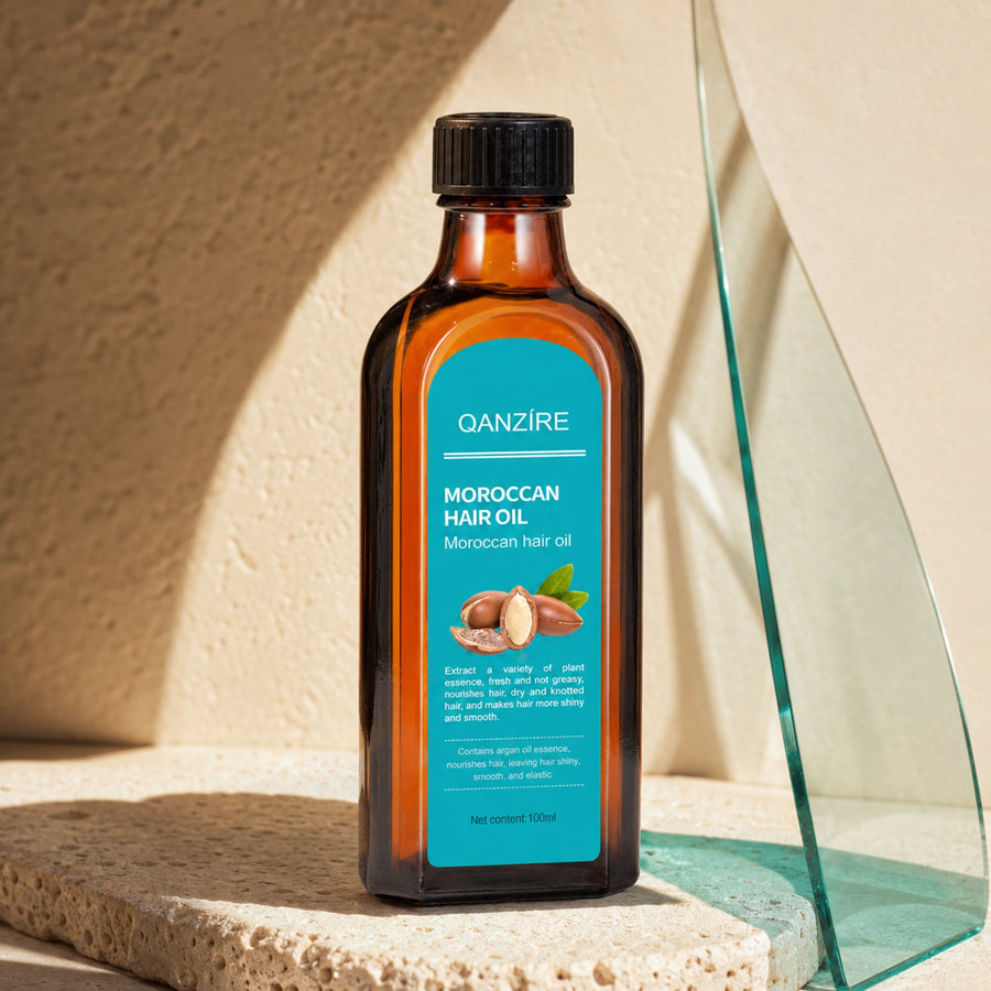 QANZIRE Moroccan Hair Oil in a warm limestone three-quarter premium product shot