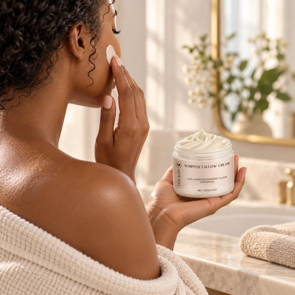 Woman applying whipped tallow cream to her cheek, jar in hand