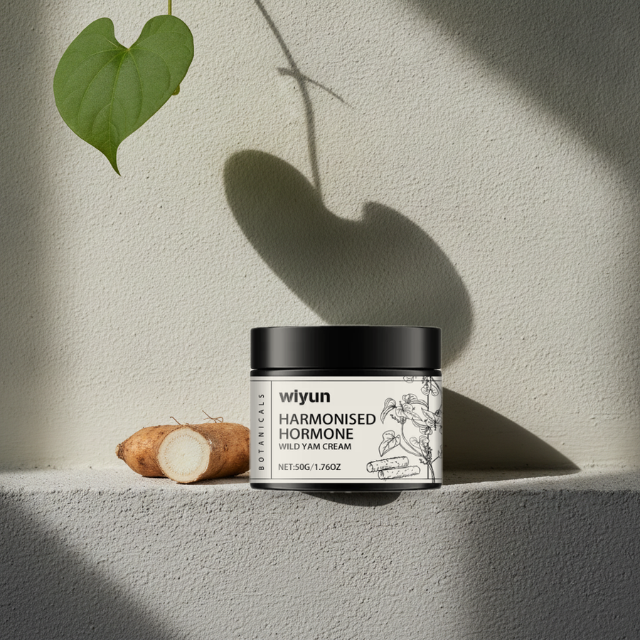 Wild Yam Cream jar on a limewashed ledge beside a cut wild yam root, vine leaf shadow on the wall